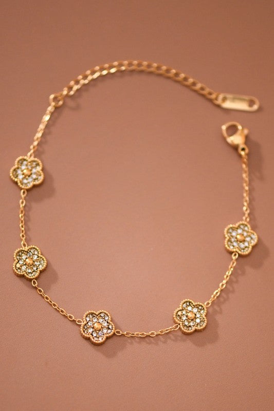 Pulsera dorada con flores y cristales
