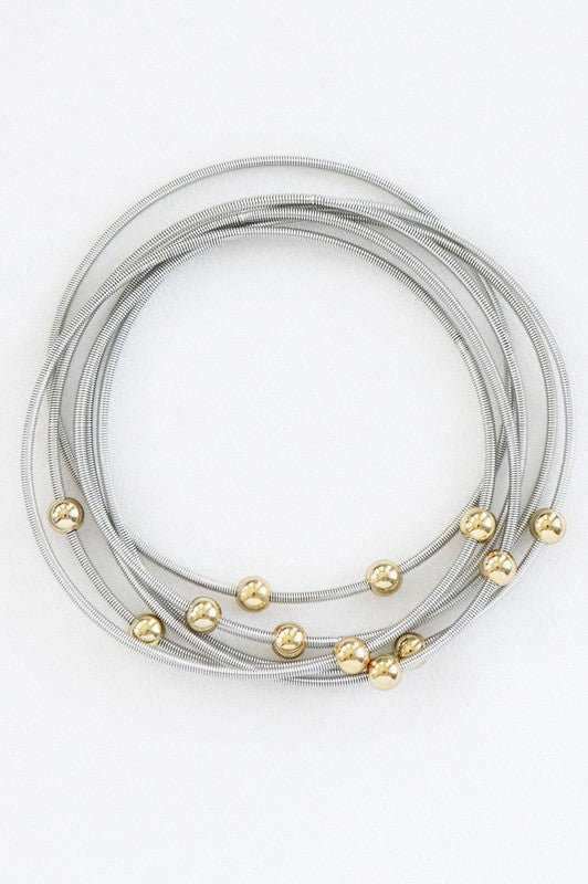 Set de pulseras plateadas con cuentas doradas