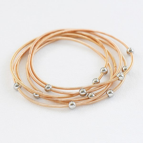 Set de pulseras doradas con cuentas plateadas