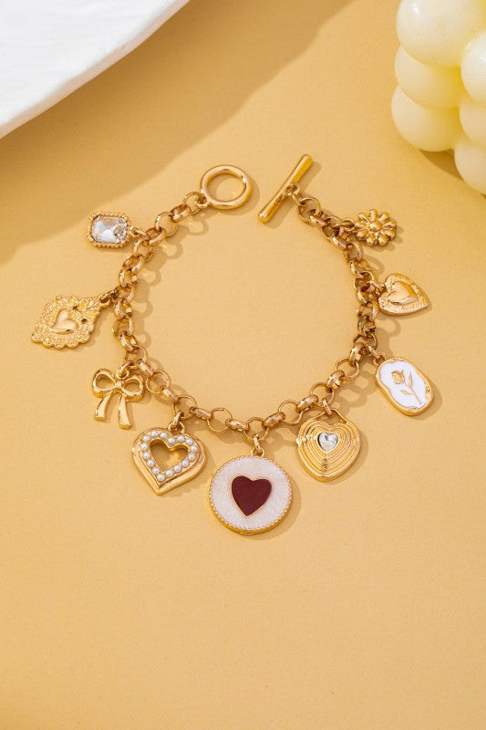 Pulsera dorada con dijes de corazones, lazo y flor