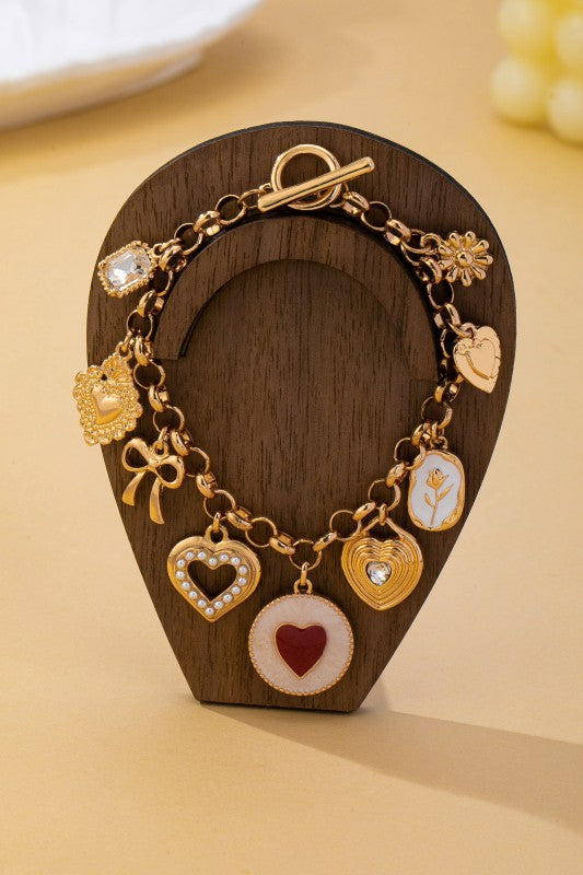 Pulsera dorada con dijes de corazones, lazo y flor
