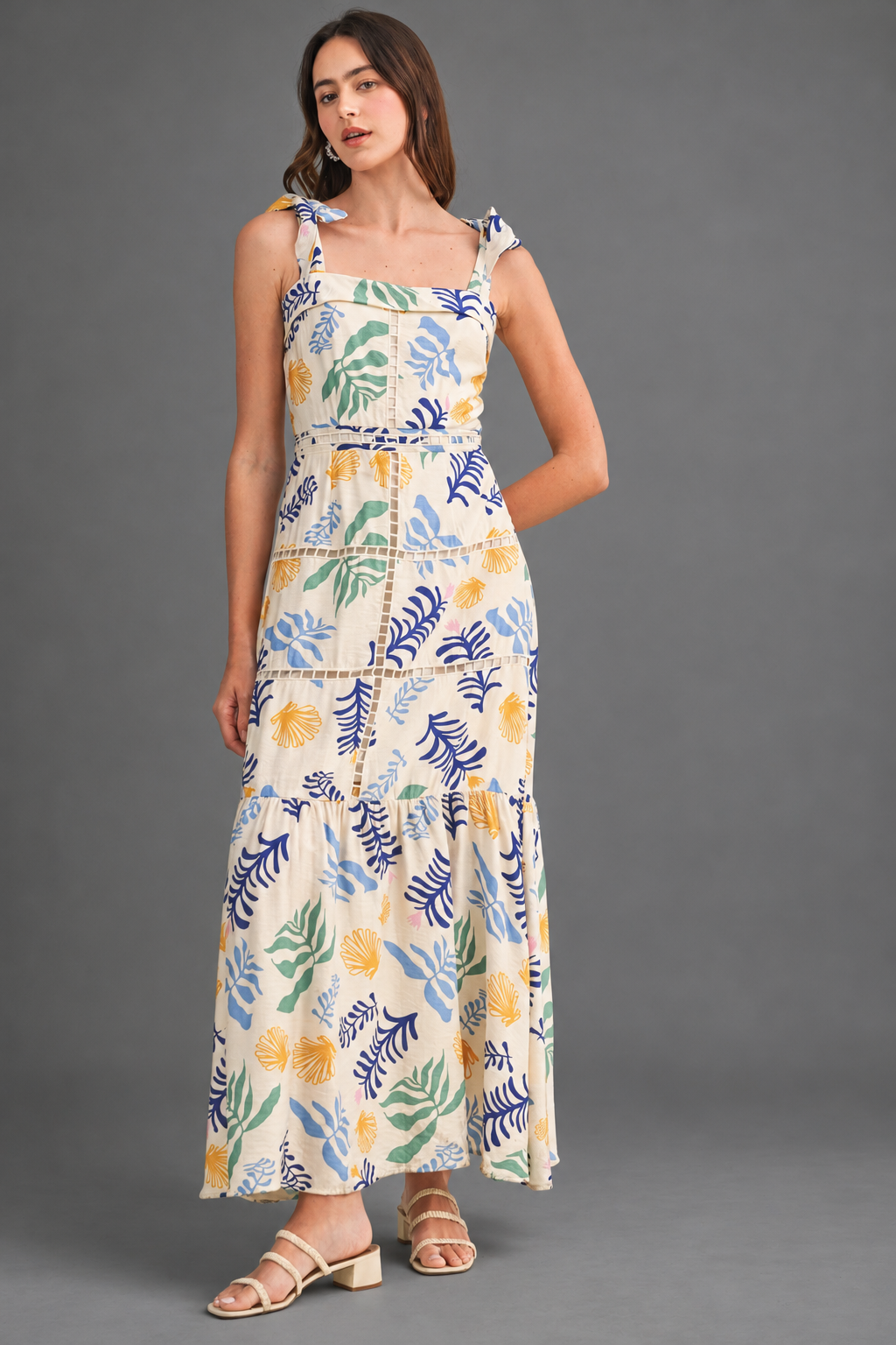 Vestido largo estampado con detalles calados sobre fondo gris de estudio