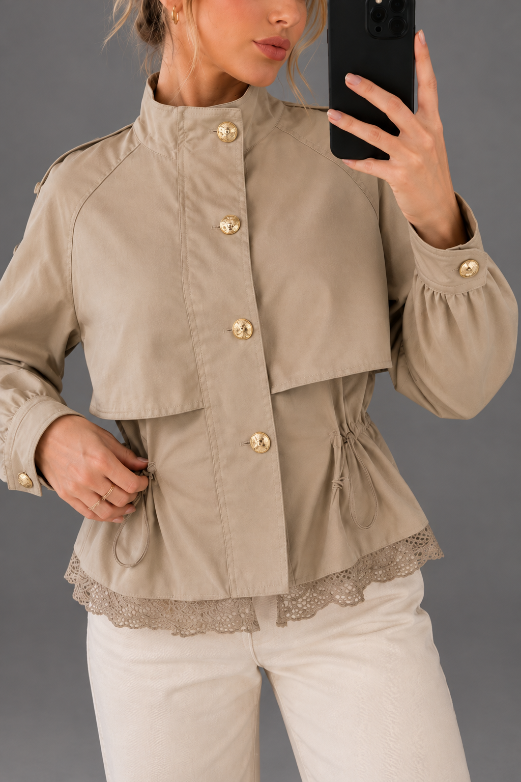 Chaqueta de cuello alto con cintura ajustable y encaje sobre fondo gris