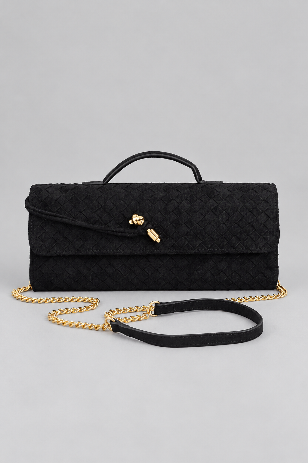 Cartera trenzada de gamuza vegana con cadena sobre fondo de estudio